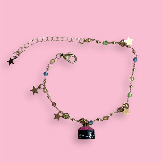 Handmade bracelet featuring a Hello Kitty sushi charm, pastel glass beads, and dangling star accents on a gold-toned chain.