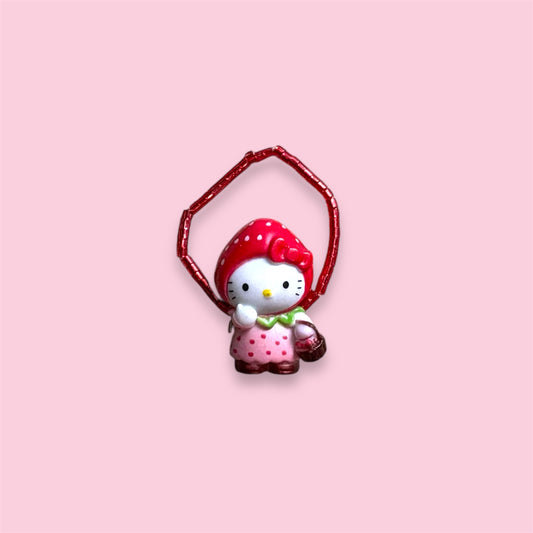 Hello Kitty Strawberry ring with red beaded band shown on hand and display on light background.