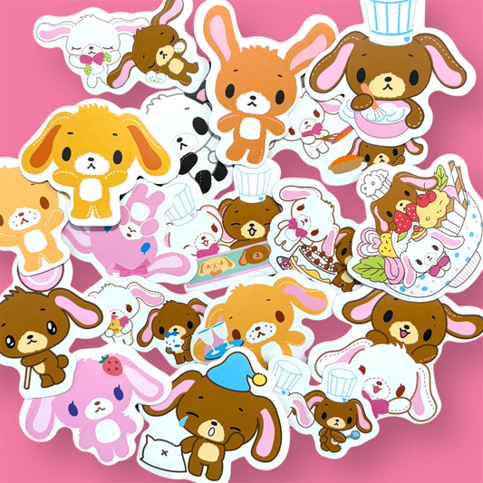 Assorted Sugarbunnies stickers with pastel-colored bunnies in baking outfits and cute poses, spread on a pink background.